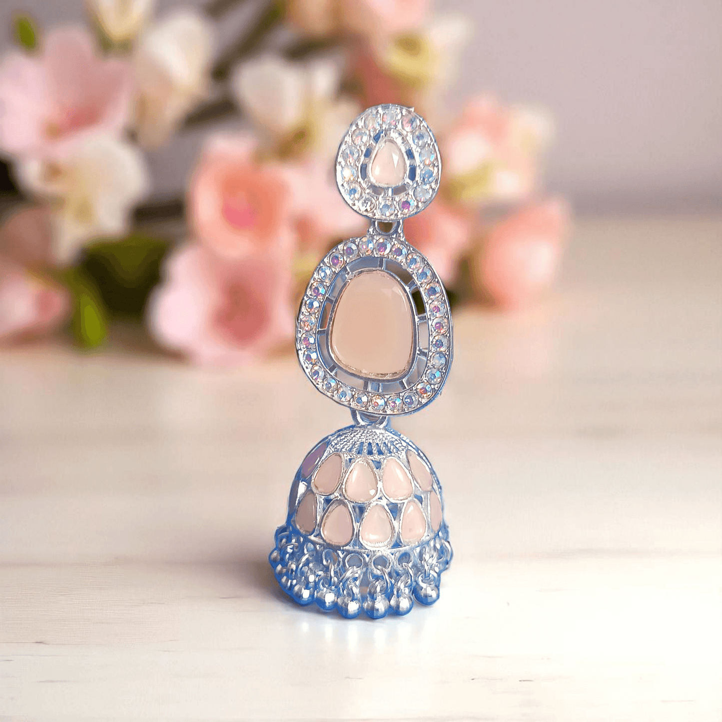 Selenesima peach oxidized jhumka earrings with embellishments against
flowers background