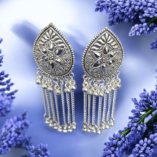 "Oxidized silver floral earrings with chain dangles on lavender background surrounded by flowers