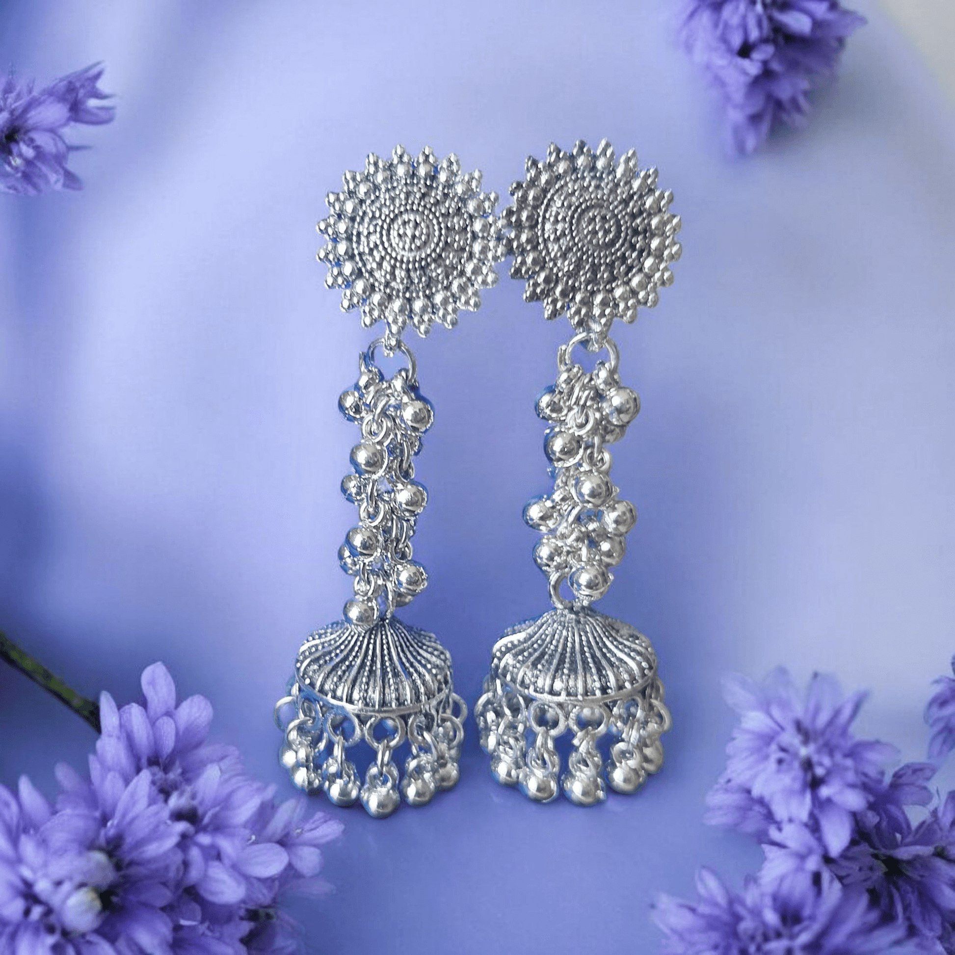 Front view of oxidized silver jhumka earrings with floral top and ghungroo detailing