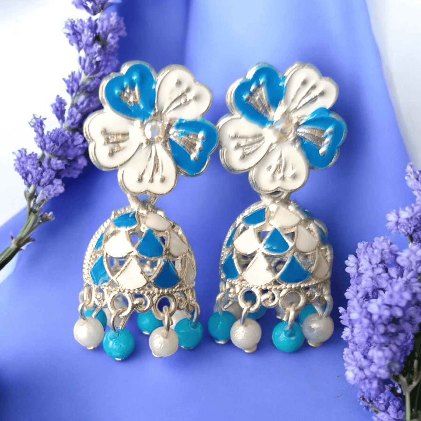 Selenesima blue floral oxidized jhumka earrings with pearls against lavender flowers background