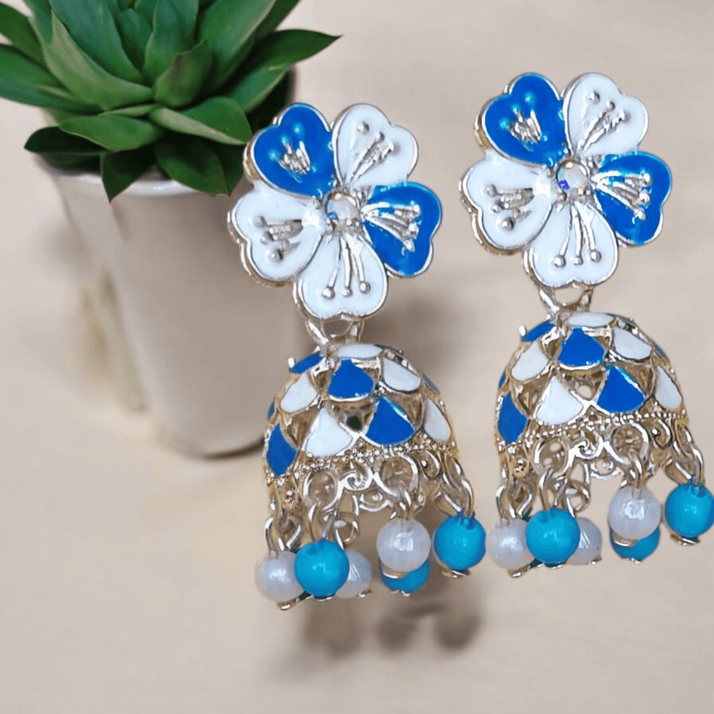 Selenesima blue floral oxidized jhumka earrings with pearls against  flowers background