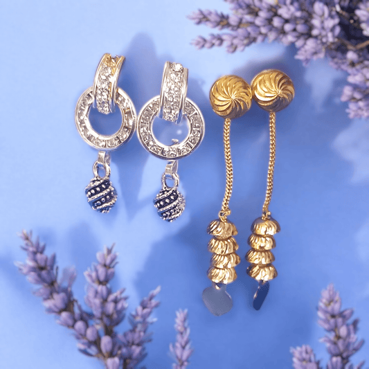 Antique gold long chain dangle earrings with stacked dome beads on a lavender and floral background"
